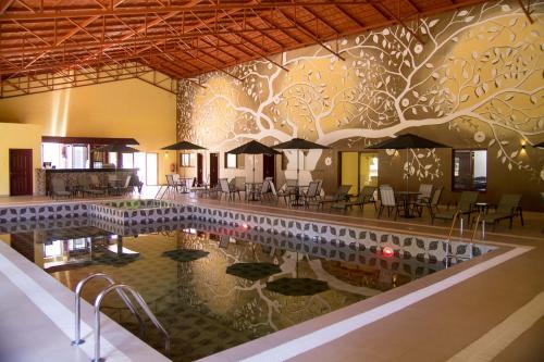 NyahururuPanari Resort, BW Signature Collection的一个带桌椅和遮阳伞的游泳池