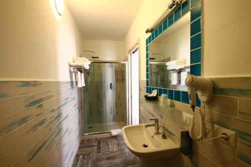 圣特雷莎加卢拉Hotel Muita di Mari的浴室配有盥洗盆和带镜子的淋浴