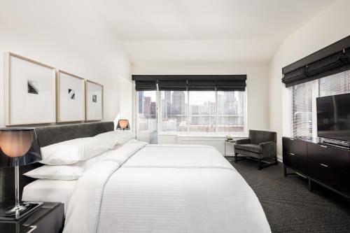 纽约AKA萨顿广场酒店的卧室设有一张白色大床和一扇窗户。