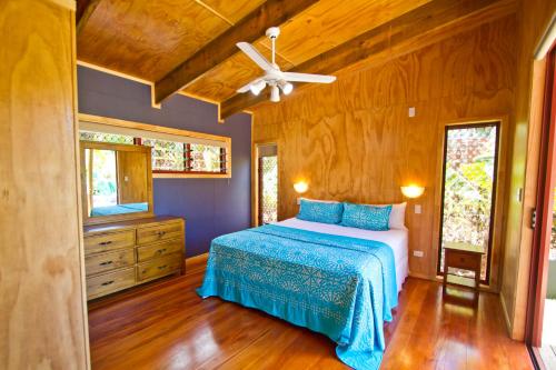 拉罗汤加拉罗汤加天堂假日别墅的一间卧室配有一张床和吊扇