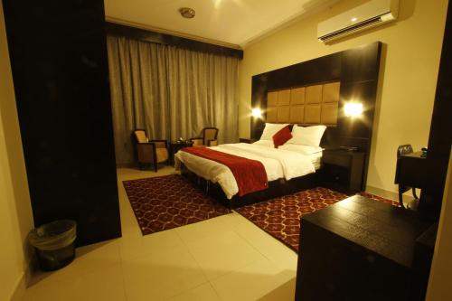 布赖代Manazel Al Hamra Apartment 2的酒店客房,配有一张带红色毯子的床
