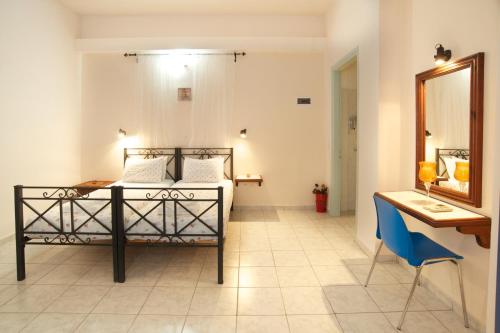 莫斯塔诺斯托斯公寓式酒店的一间卧室配有一张床、一张书桌和一面镜子