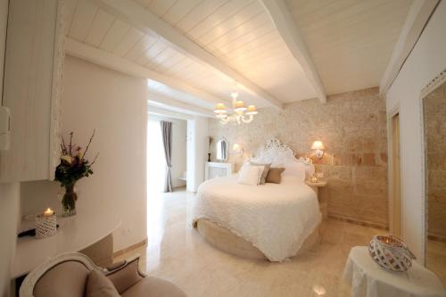 莫诺波利Playa del Mar - Adults Only的卧室配有白色的床和吊灯。