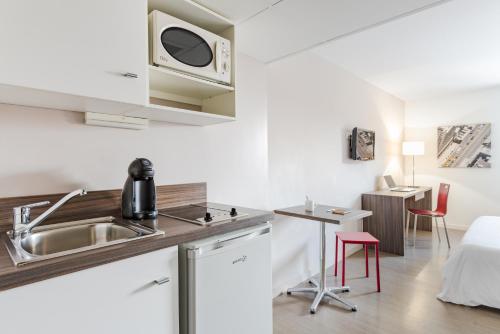 瓦朗斯厄瓦酒店的厨房配有水槽和微波炉