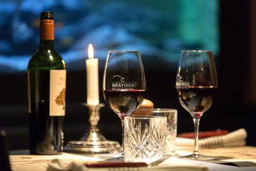 乌德瓦拉Quality Hotel Carlia的桌子上放两杯葡萄酒,还有一瓶葡萄酒