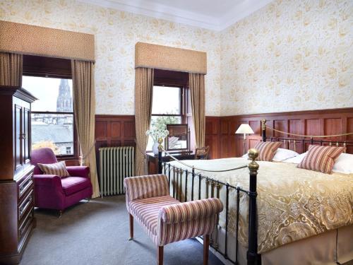 爱丁堡Hapimag Resort Edinburgh的一间卧室配有一张床和一把椅子
