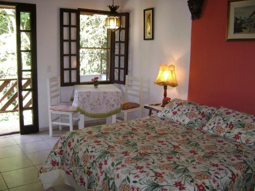 伊利亚贝拉Vila São Pedro的卧室配有一张床和一张桌子及椅子