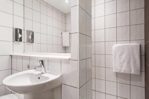 斯丹斯达蒙费雪特华美达伦敦斯坦斯特德机场酒店的白色的浴室设有水槽和镜子