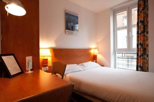 斯特拉斯堡21世纪酒店的酒店客房设有一张床、一张书桌和窗户。