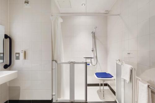 科巴姆Ramada by Wyndham Cobham的带淋浴和盥洗盆的白色浴室
