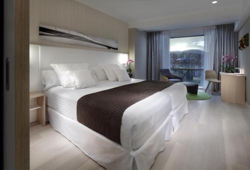 毕尔巴鄂巴塞罗毕尔巴鄂奈维翁酒店的卧室设有一张大白色的床和大窗户
