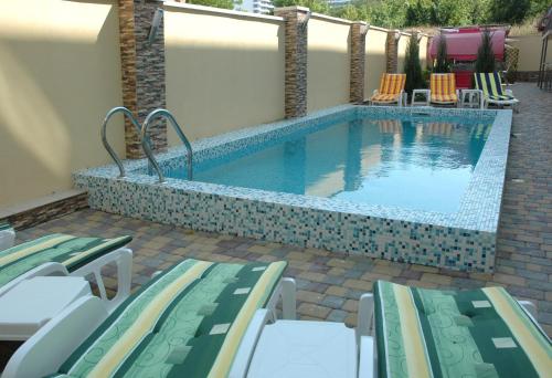 敖德萨巴拿马别墅的一个带躺椅的游泳池和一个游泳池