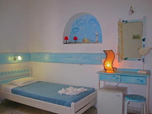 米克诺斯城凯马塔酒店的一间卧室配有一张床、一张书桌和一面镜子