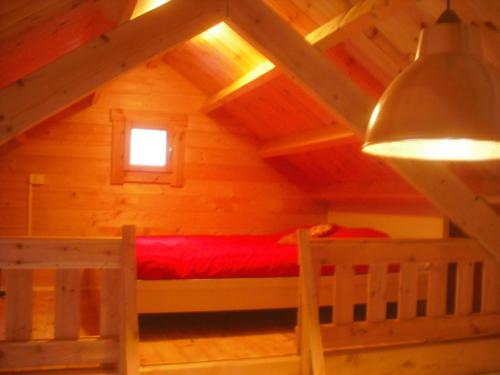 米茹蒙茨朱拉木屋的小木屋内的卧室,配有红色的床