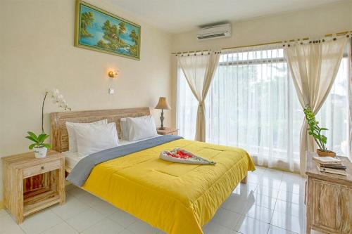 塞米亚克钱德拉别墅酒店的一间卧室配有一张黄色床罩的床