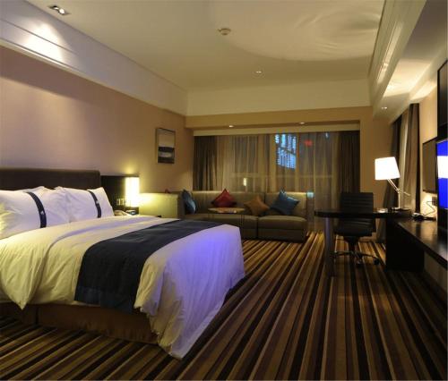 沈阳沈阳金廊智选假日酒店  的酒店客房,配有床和沙发