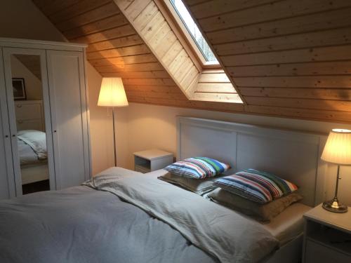 米泽德沃兹Domek Wakacyjny Na Złotych Wydmach的一间卧室配有一张带两个枕头的床和天窗