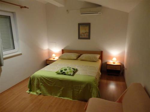 皮罗瓦茨Apartments Sljuka的一间卧室配有床,两台桌子上有两个灯