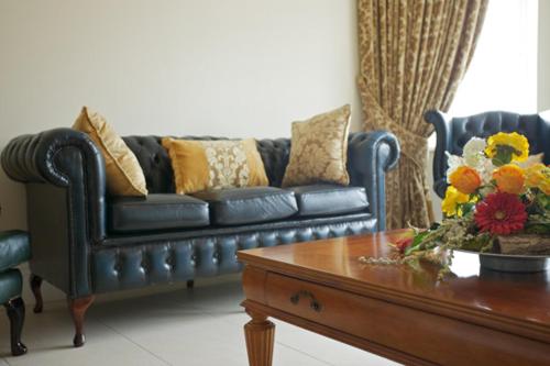 班克拉那St Columbs House的客厅配有蓝色的沙发和茶几