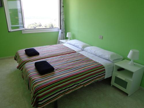 波尔托马林波尔托马林阿科瓦旅舍的一间设有床铺的卧室,位于带窗户的绿色客房内