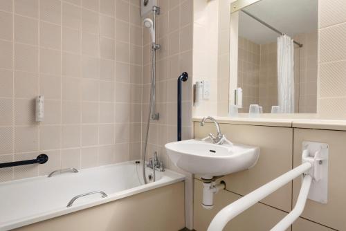 如不斯桥戴斯塞奇莫尔酒店的浴室配有盥洗盆和浴缸。