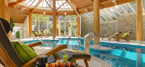 肯梅尔谢恩瀑布小屋酒店的一座带椅子的别墅内的游泳池和一座游泳池