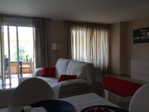 EsteponaLa Galera Park House的客厅配有带红色枕头的白色沙发