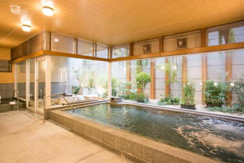 福冈克鲁姆博西铁酒店的一座带大窗户的建筑中的游泳池