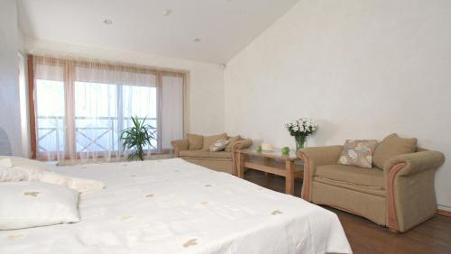 尤尔马拉坦尼撒克鲁斯尤拉酒店的一间卧室配有一张床、两把椅子和一个窗户