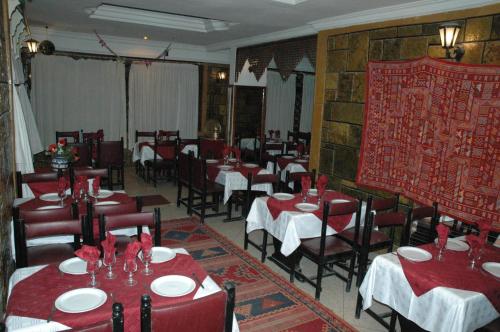塔鲁丹特提奥特酒店的用餐室配有桌椅和红色的桌椅