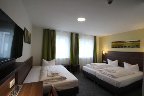 美因河畔法兰克福Goethe Conference Hotel by Trip Inn的酒店客房设有两张床和一台平面电视。