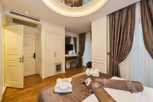 伊斯坦布尔达客门酒店2的一间卧室配有一张大床,上面有白色毛巾