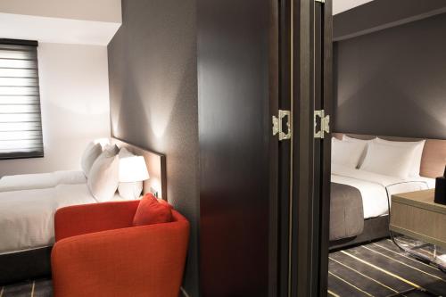 埃里温埃里温新星酒店的酒店客房,配有一张床和一张红色椅子
