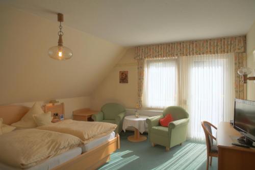 温特贝格宙斯切勒宝恩斯图本旅馆的一间卧室配有一张床、一台电视和椅子