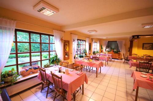 巴特欧波维德纳酒店的餐厅设有桌椅和大窗户。