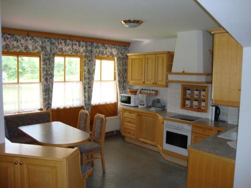 弗拉绍假日公寓 的一间带木制橱柜和桌子的厨房以及一间用餐室