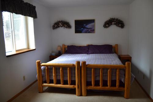 基奈All Seasons B&B的一间卧室设有木床和2个窗户。