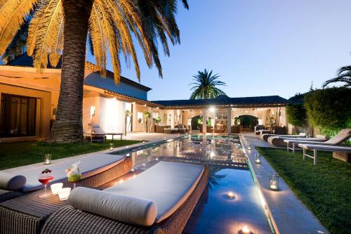 圣特罗佩前海酒店的一个带躺椅和棕榈树的室外游泳池