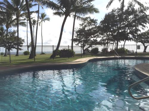 卡帕阿珊瑚礁酒店的围栏前的棕榈树游泳池