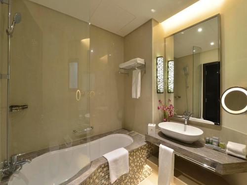 麦纳麦海湾行政公寓酒店的带浴缸、水槽和镜子的浴室