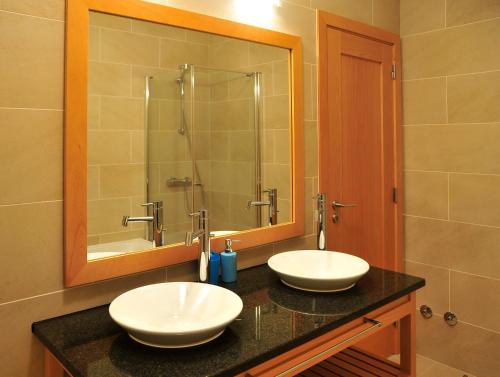 普拉亚德尔瑞伊Praia Del Rey SeaView Dupplex的一间带两个盥洗盆和大镜子的浴室