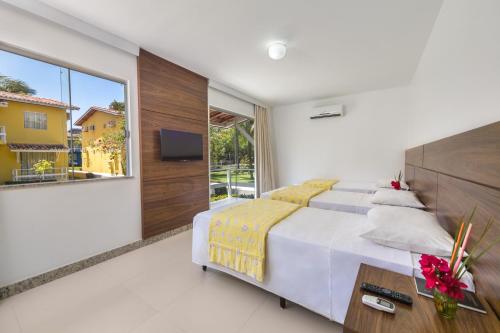 塞古罗港Atlântida Park Hotel的一间卧室设有一张大床和一个大窗户