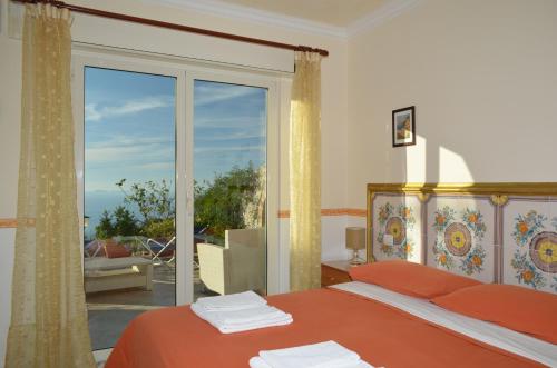 阿纳卡普里Le Ginestre di Capri BB & Holiday House的一间卧室设有一张床和一个大型玻璃窗