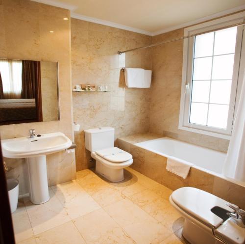格尔尼卡Hotel Gernika - Adults Only的浴室配有盥洗盆、卫生间和浴缸。