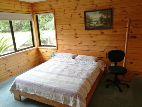 蚌贝Beaver Farm House的一间卧室配有一张床和一把椅子