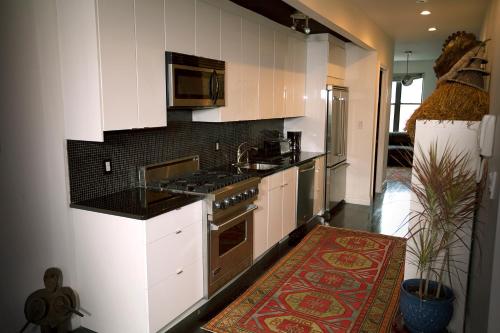 纽约画廊之家公寓的厨房配有白色橱柜和炉灶烤箱。