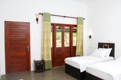 蒂瑟默哈拉默亚拉维海德度假村的一间卧室设有两张单人床和一扇门