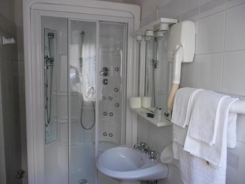 雷卡纳蒂Hotel Ristorante La Ginestra的带淋浴和盥洗盆的白色浴室