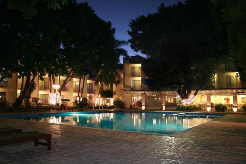 比亚埃尔莫萨维瓦维拉尔莫萨酒店的一座游泳池,在晚上在建筑物前