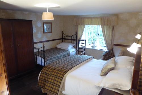 安布尔塞德海锐农场住宿加早餐旅馆的一间卧室设有两张床和窗户。